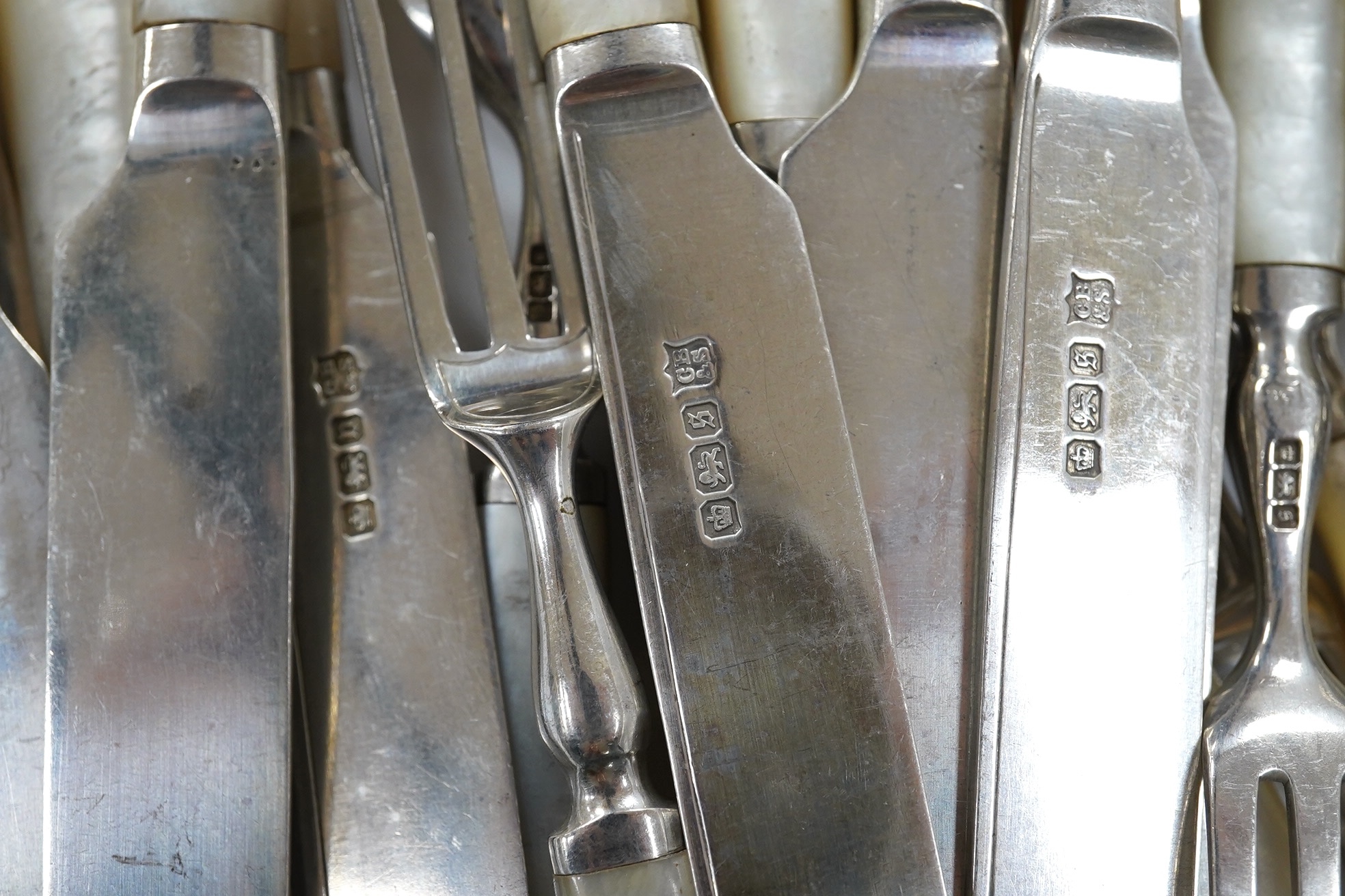 Ten George V mother of pearl handled silver dessert eaters and eleven matching forks, Cooper Brothers & Sons, Sheffield, 1910/13. Condition - fair